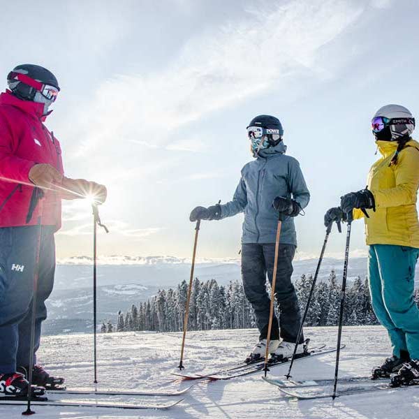 Two skiers standing with their instructor