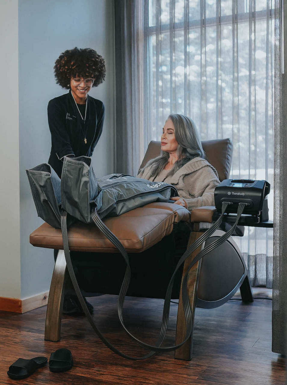 Spa employee attending a woman sitting in an anti-gravity chair